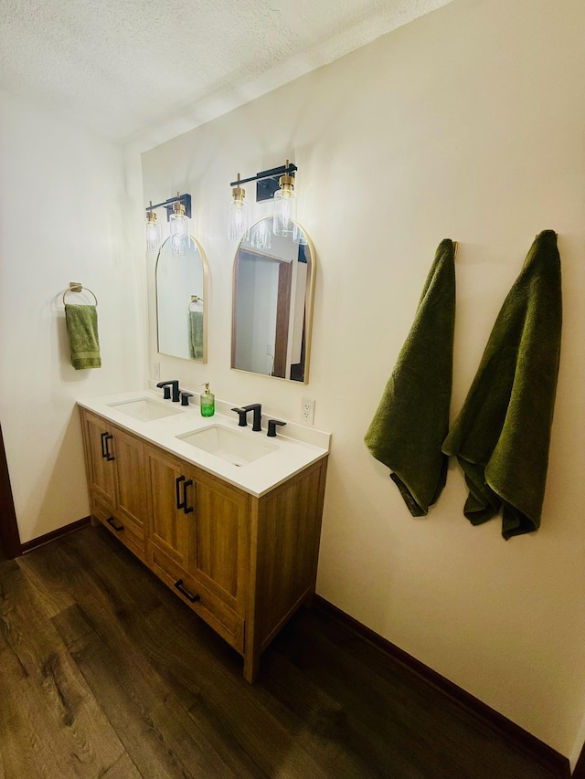 bathroom with wood finished floors, baseboards, and a sink