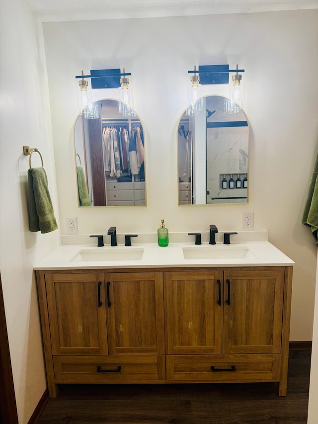 bathroom featuring double vanity, baseboards, and a sink