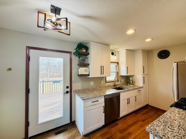 kitchen with visible vents, white cabinetry, stainless steel appliances, and a sink