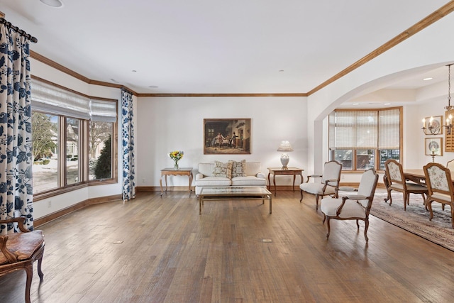 living area featuring a wealth of natural light, wood-type flooring, and a chandelier