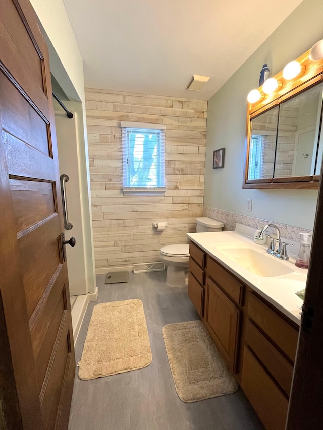 361 Hollett St, Tracy, MN 56175 - bathroom featuring wood walls, vanity, a shower stall, and wood finished floors