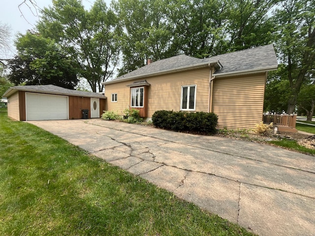 361 Hollett St, Tracy, MN 56175 - view of front of property with an outdoor structure, concrete driveway, a detached garage, and a front lawn