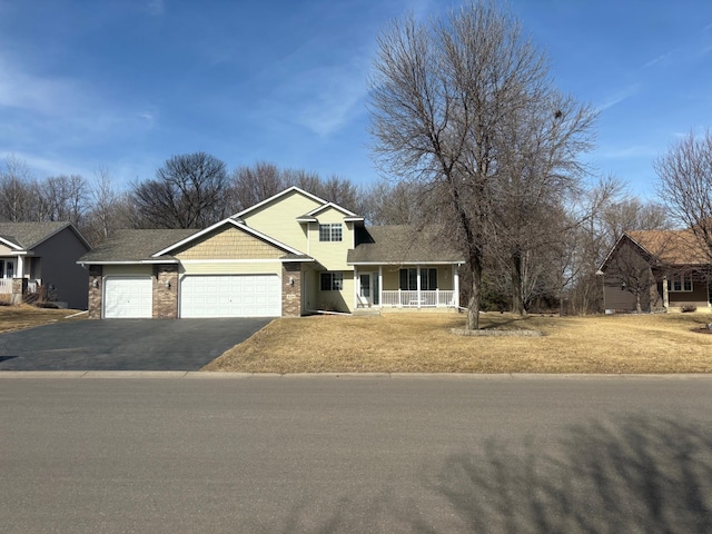 view of front of home with aphalt driveway, a front lawn, covered porch, and an attached garage