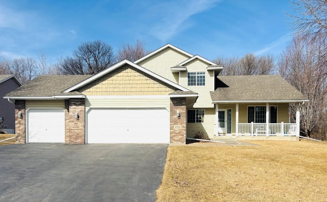 view of front of home with covered porch, a front lawn, a garage, aphalt driveway, and brick siding