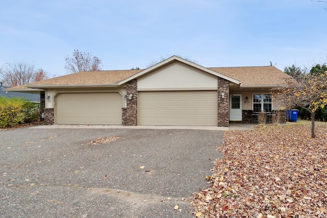 single story home with brick siding, a garage, and driveway