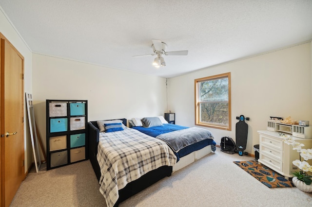 bedroom with ceiling fan, carpet floors, and a textured ceiling