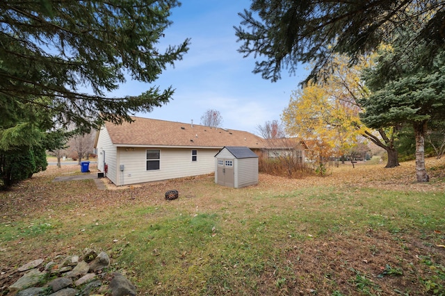 back of house featuring an outbuilding, a shed, and a yard