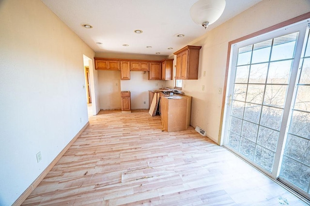 kitchen with recessed lighting, baseboards, light wood-style floors, and brown cabinetry