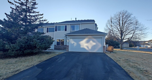 traditional-style house with driveway, brick siding, and an attached garage