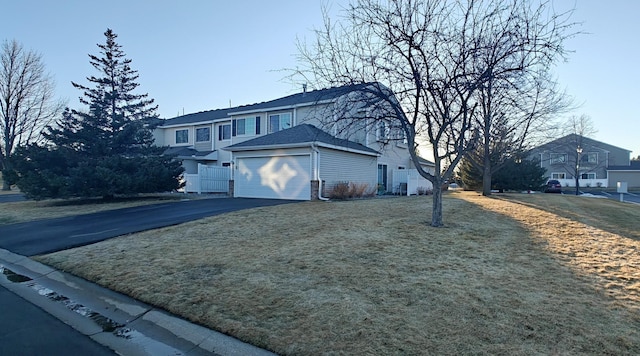 view of front of house with aphalt driveway, a residential view, and a garage