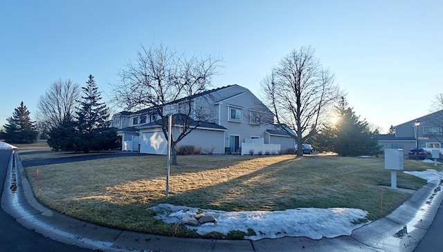 view of side of home with a yard, driveway, and a garage