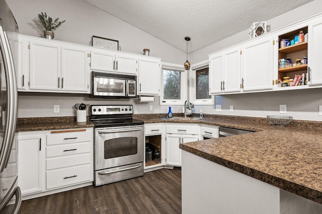 kitchen with a sink, dark countertops, appliances with stainless steel finishes, lofted ceiling, and dark wood-style flooring