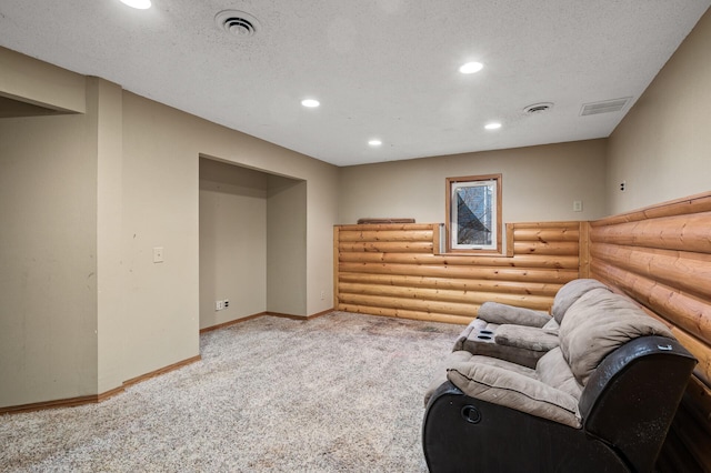 living area with baseboards, visible vents, recessed lighting, a textured ceiling, and rustic walls