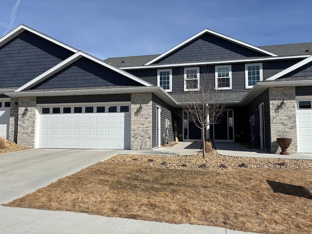 view of front of house with brick siding, a garage, and driveway