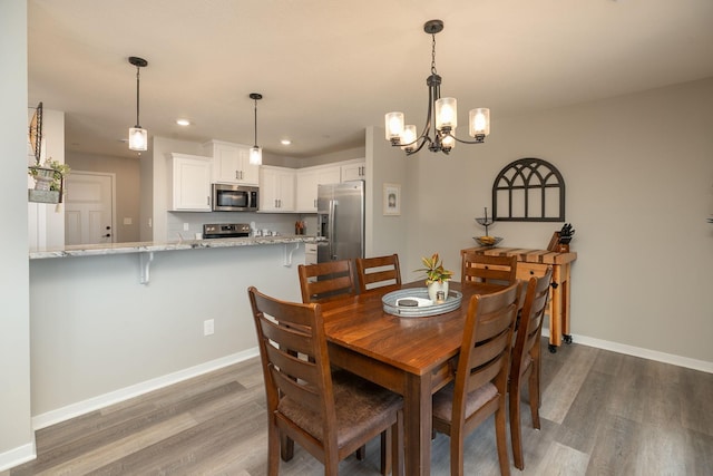 dining room with recessed lighting, baseboards, and dark wood finished floors