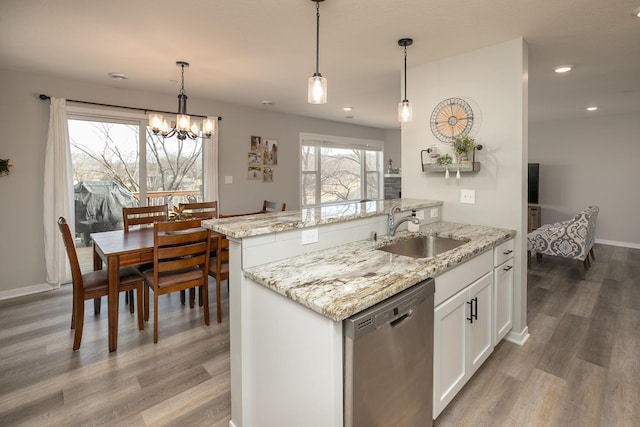 kitchen featuring wood finished floors, white cabinetry, a sink, pendant lighting, and dishwasher