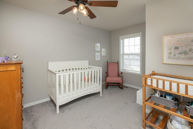 bedroom with baseboards, carpet floors, and a nursery area