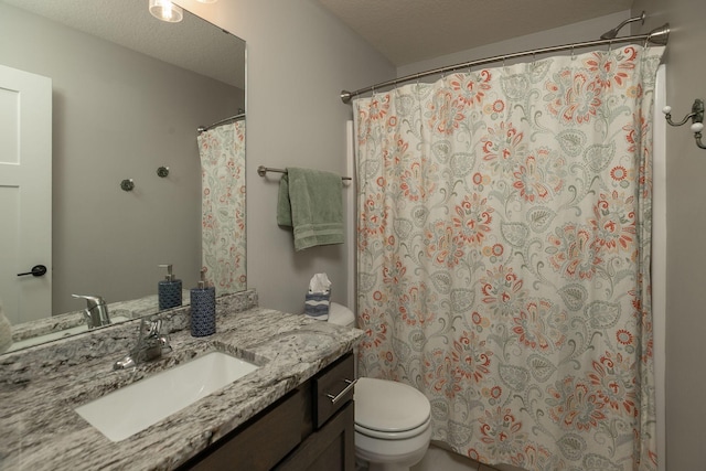 full bathroom featuring vanity, toilet, and a textured ceiling