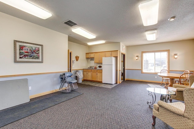 interior space with visible vents, dark carpet, a textured ceiling, and baseboards