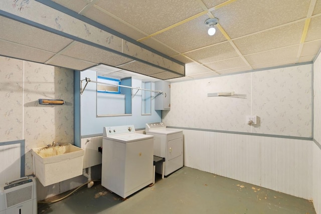 laundry room with laundry area, separate washer and dryer, and a sink