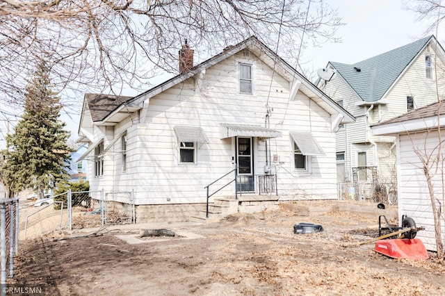 back of property featuring a chimney and fence