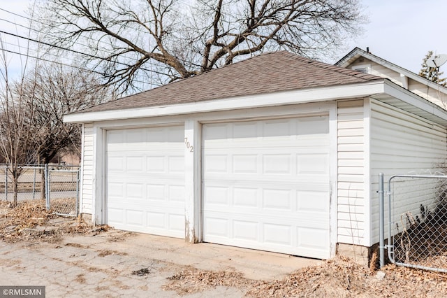 detached garage with a gate and fence