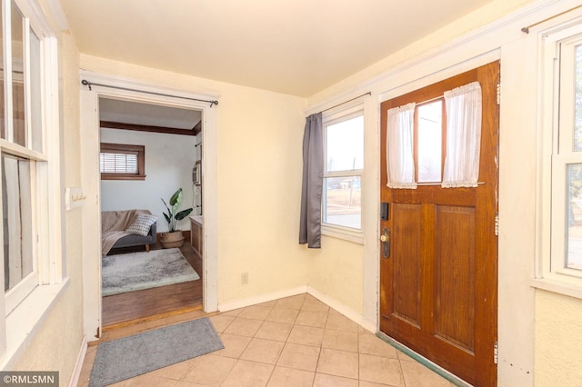 entrance foyer featuring a wealth of natural light, light tile patterned floors, and baseboards