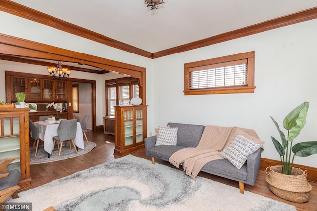 living room featuring an inviting chandelier, plenty of natural light, and wood finished floors