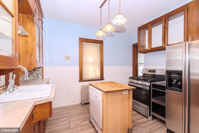 kitchen featuring a wainscoted wall, a sink, wood counters, radiator, and appliances with stainless steel finishes