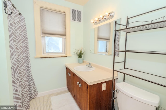 bathroom featuring a wealth of natural light, visible vents, toilet, and vanity