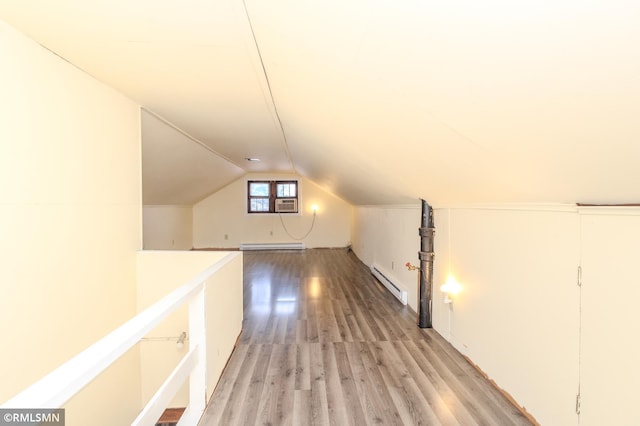 additional living space with baseboard heating, light wood-style flooring, a baseboard heating unit, and lofted ceiling