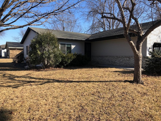 exterior space with a front lawn and brick siding