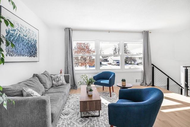 living area featuring visible vents and wood finished floors