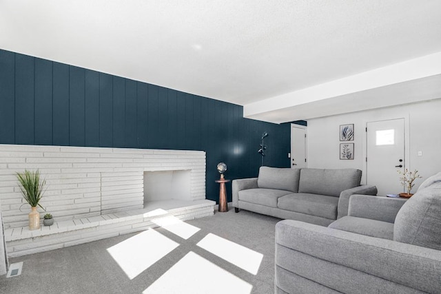 carpeted living room with visible vents and a fireplace