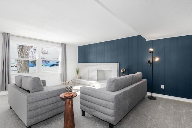 carpeted living area with baseboards and a brick fireplace