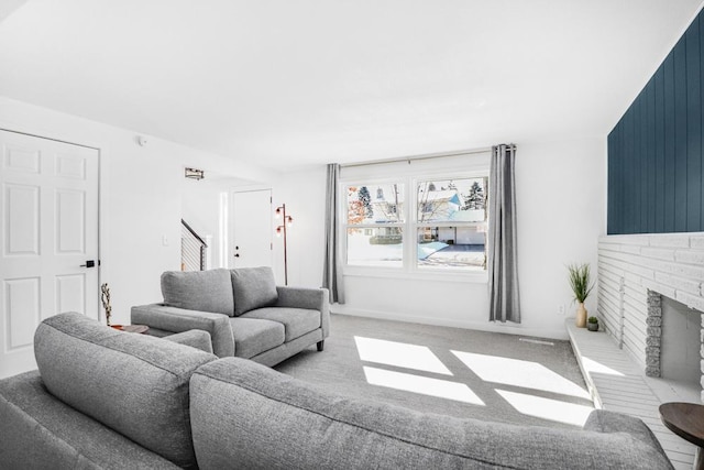 carpeted living area featuring stairs and a fireplace