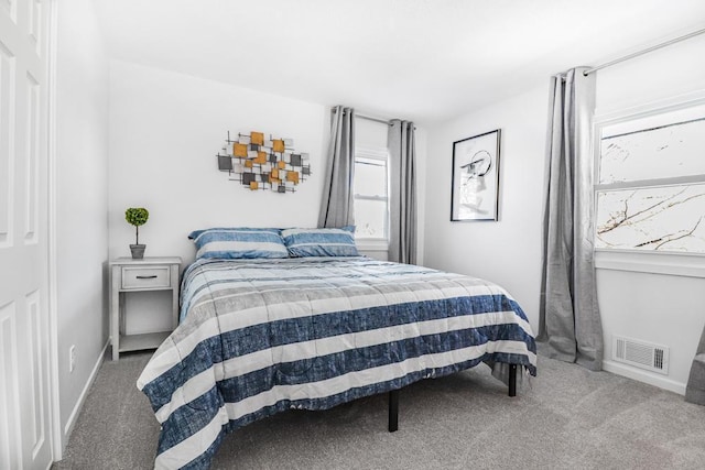 carpeted bedroom featuring visible vents and baseboards