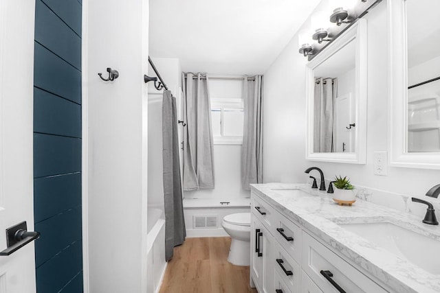 full bathroom with toilet, wood finished floors, visible vents, and a sink