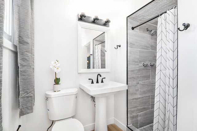 full bathroom featuring a tile shower and toilet