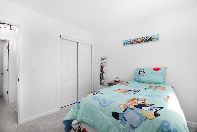 bedroom with a closet, carpet flooring, and baseboards