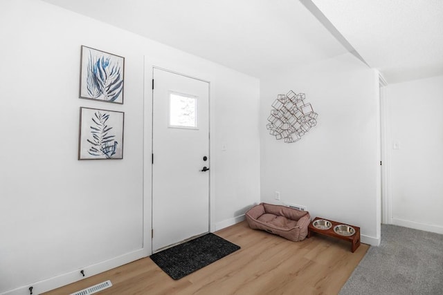 entrance foyer with visible vents, baseboards, and wood finished floors