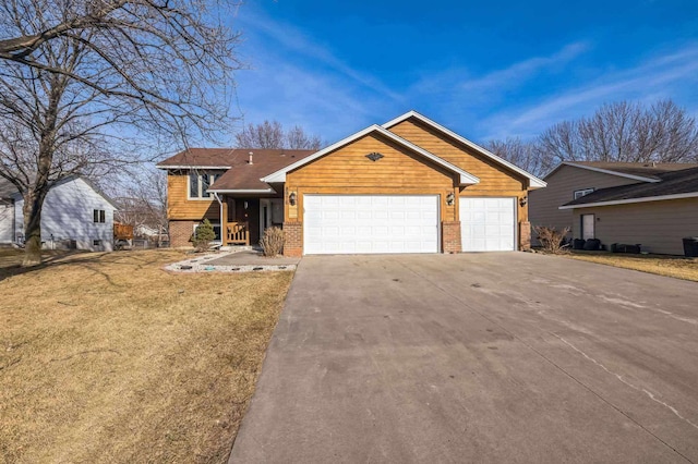 view of front of home featuring a front yard, brick siding, concrete driveway, and an attached garage