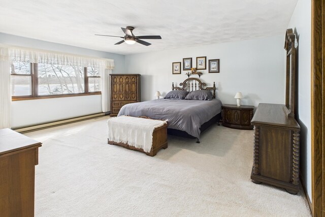 bedroom featuring light colored carpet, a baseboard heating unit, and ceiling fan