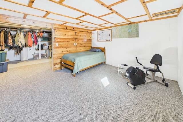 bedroom with carpet and concrete block wall