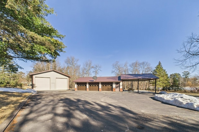 exterior space featuring metal roof, an outbuilding, and a garage