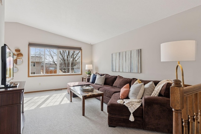 living area featuring baseboards, lofted ceiling, and light colored carpet