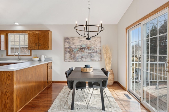 dining area with a chandelier, visible vents, light wood finished floors, and baseboards