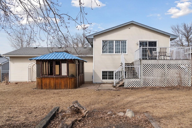 rear view of property featuring a deck and a shingled roof