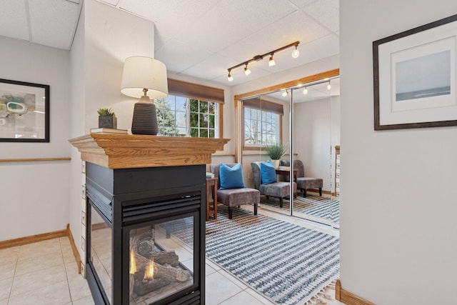 interior space with track lighting, light tile patterned floors, and baseboards