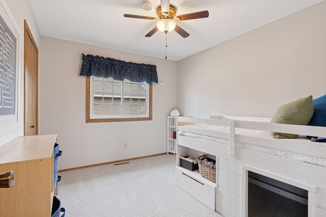 bedroom with visible vents, baseboards, light colored carpet, and ceiling fan